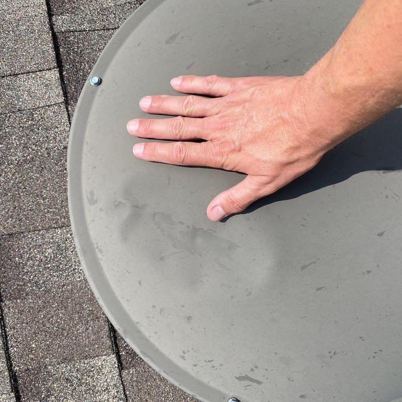 Satellite dish surface dented with hand for scale