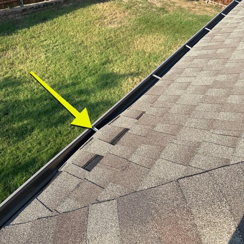 Asphalt shingles with damaged and missing tabs near gutter