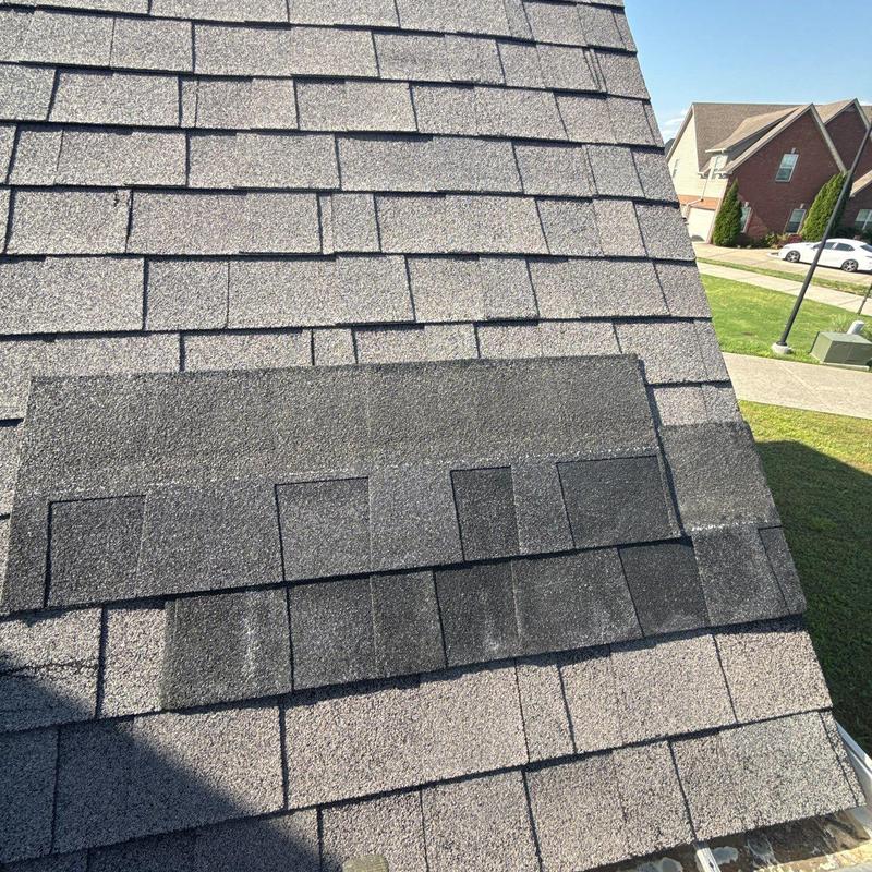 Roof shingles with hail damage and repair patch