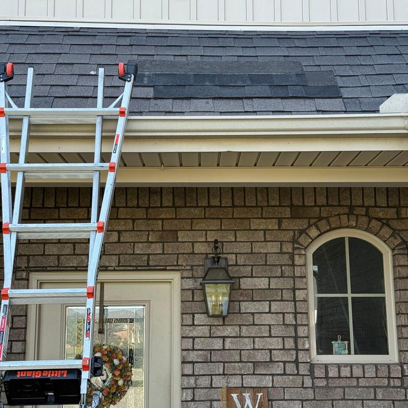Roof shingles with hail damage and ladder on house exterior
