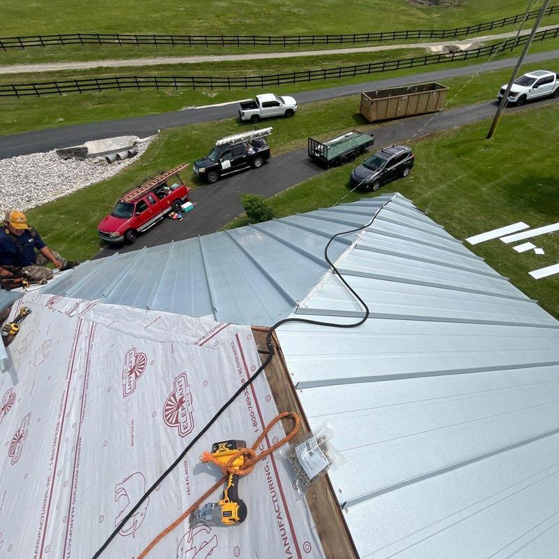 Metal roof panel installation with safety harness on site