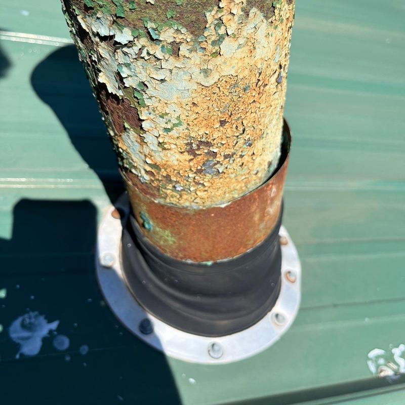 Metal roof pipe flashing with rust and peeling paint