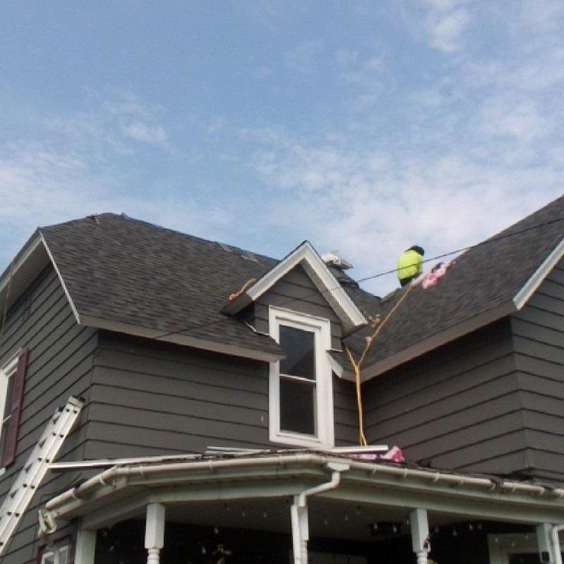 Asphalt shingle roof installation on gray house