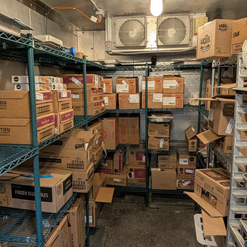 Walk-in freezer refrigeration unit with stocked shelves