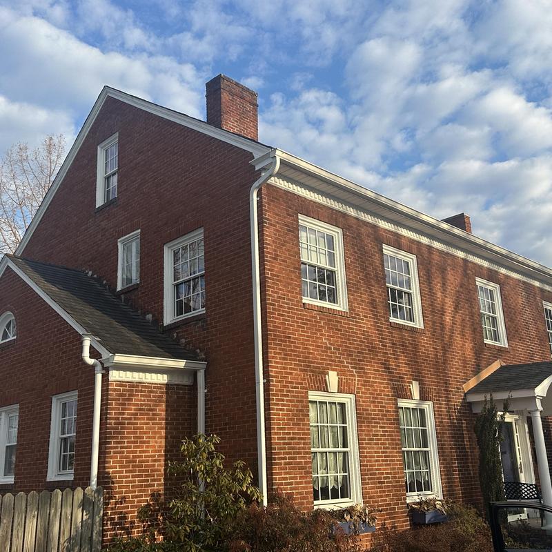 Residential shingle roof on brick house under daylight sky