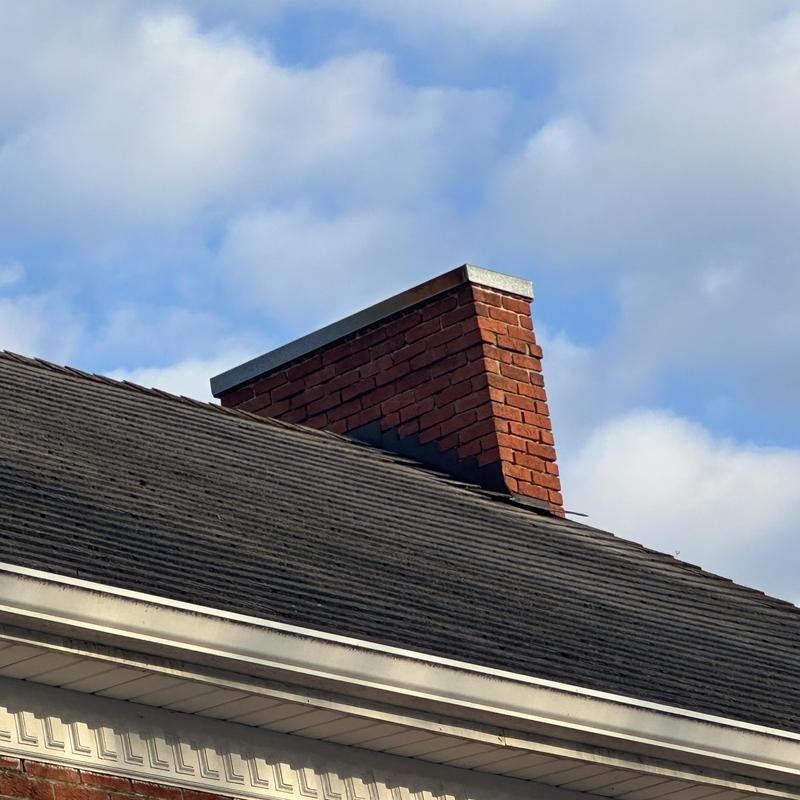 Roof shingles on residential home with brick chimney