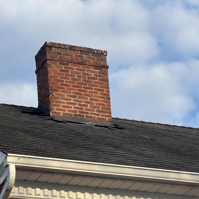 Asphalt shingle roof with brick chimney flashing