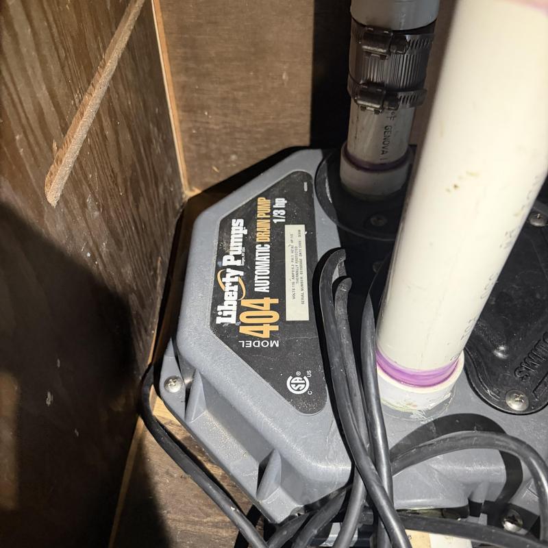 Drain pump with connected PVC pipes and wiring