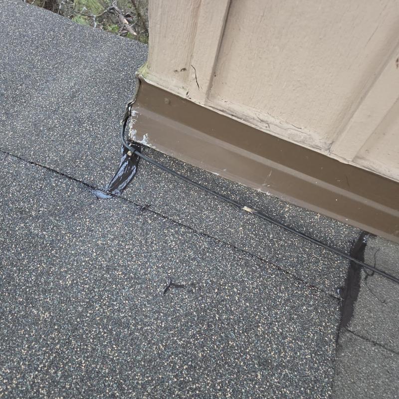 Roof flashing with sealant applied near siding trim