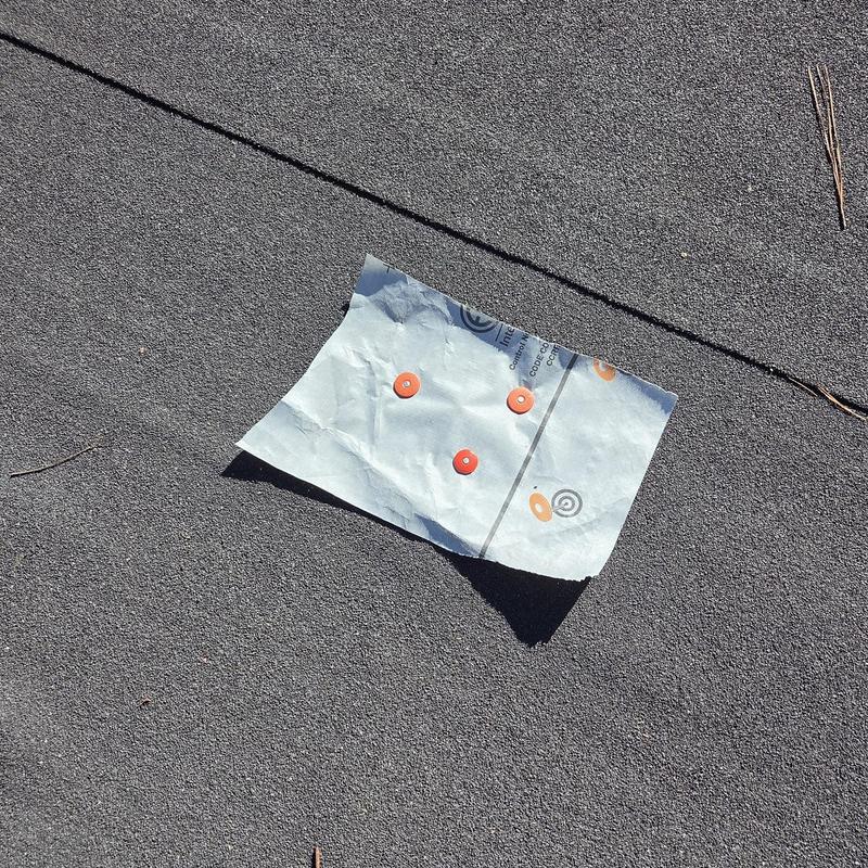 Roofing nail pop patch with fasteners on roof surface