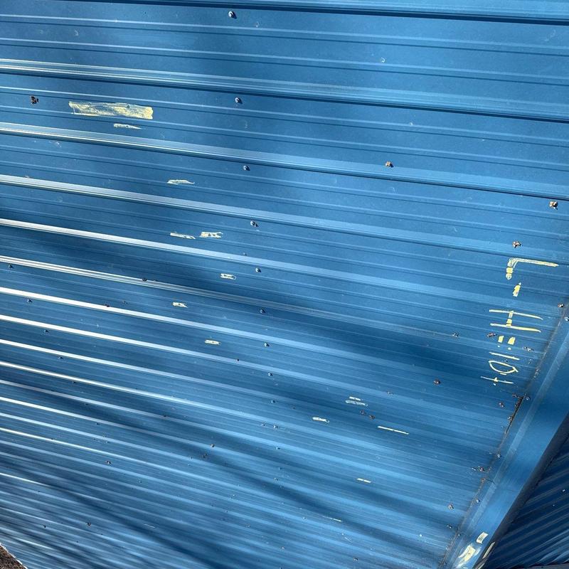 Metal roofing panel with hail damage and markings