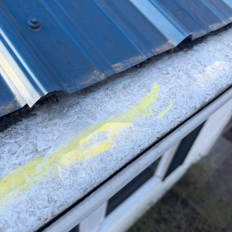 Metal flashing with hail damage and yellow markings
