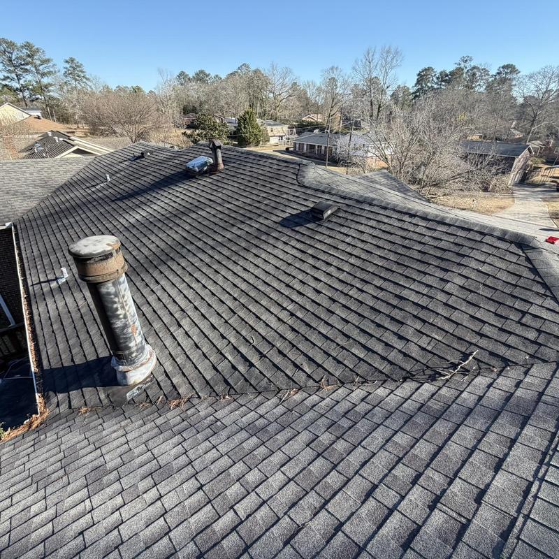 Asphalt shingle roof with visible wear and ventilation pipes