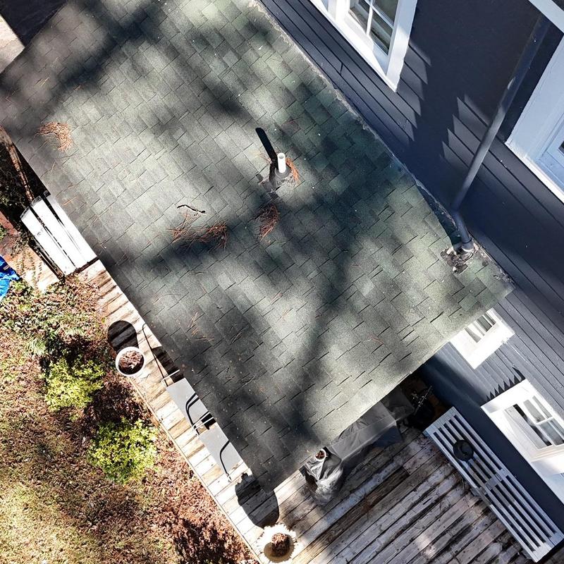 Asphalt shingle roof with vent pipes and deck below