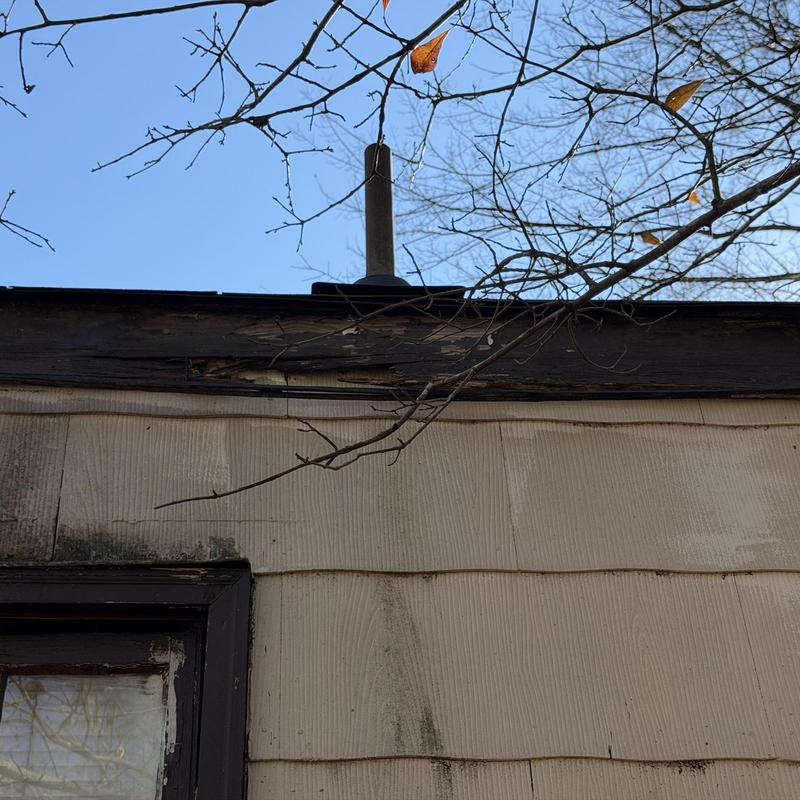 Wood fascia and soffit with weather damage on house exterior