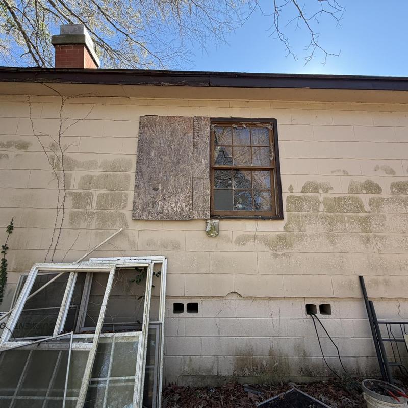 Wood window with broken glass and plywood patch