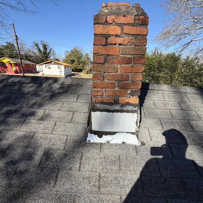 Chimney flashing on gray asphalt shingle roof