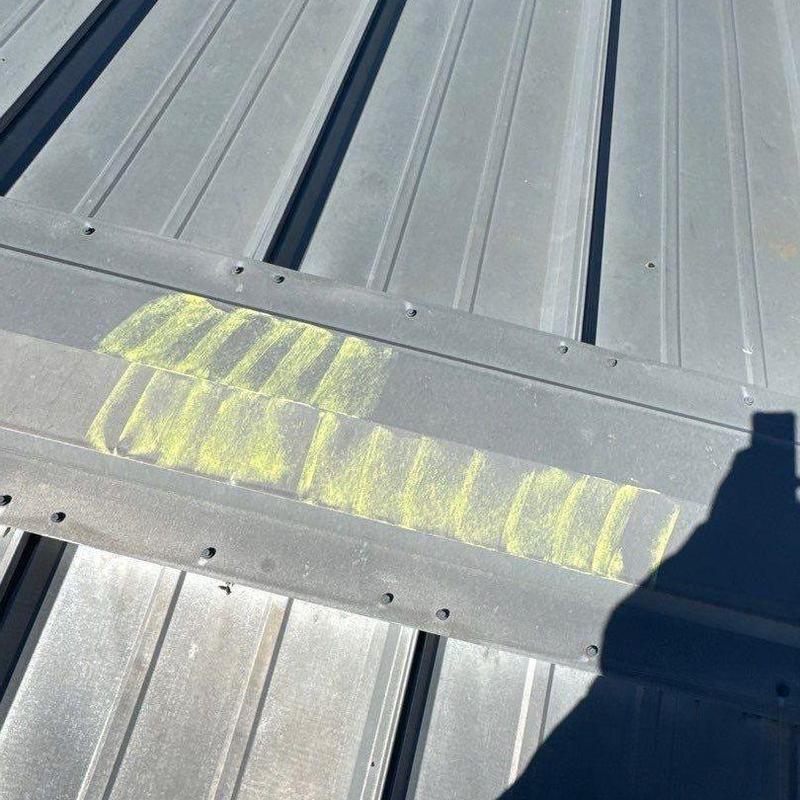 Metal roof flashing with hail damage marked in yellow
