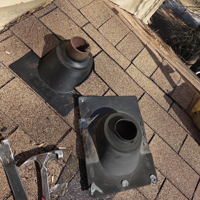 Pipe boots on shingled roof with tools nearby