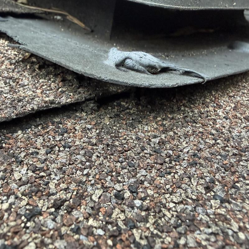 Box vent flashing edge on asphalt shingle roof close-up