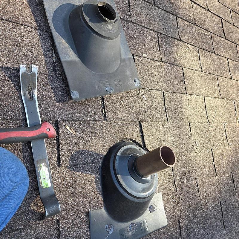 Pipe boot on shingled roof with pry bar nearby