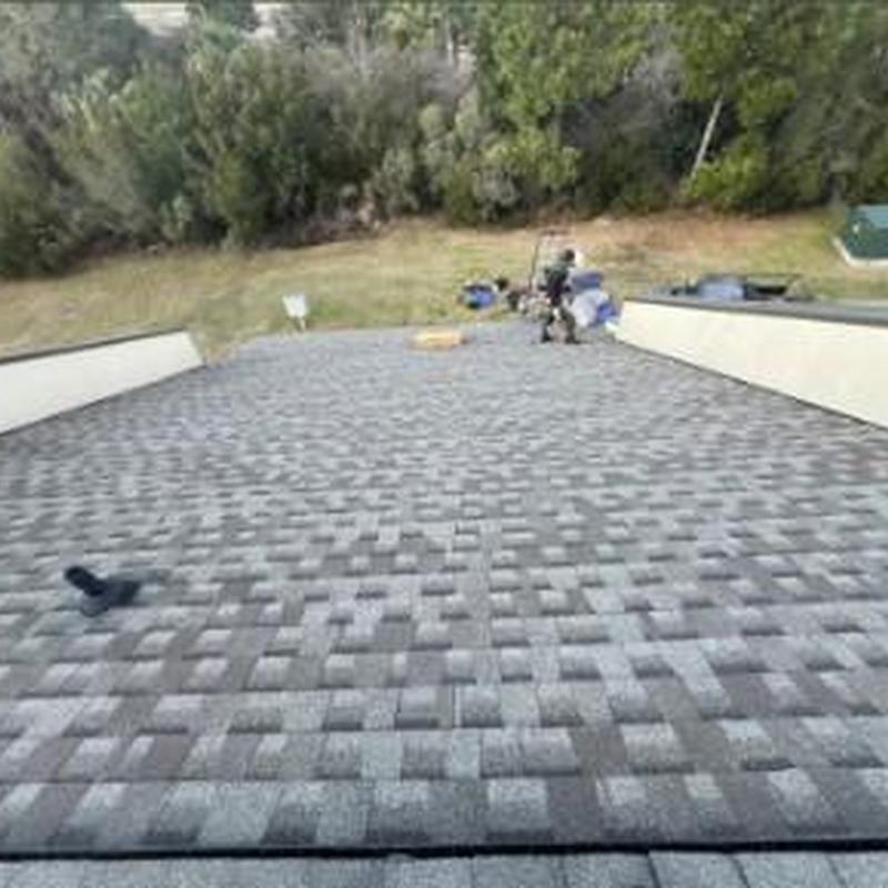 Asphalt shingle roof on townhouse with workers