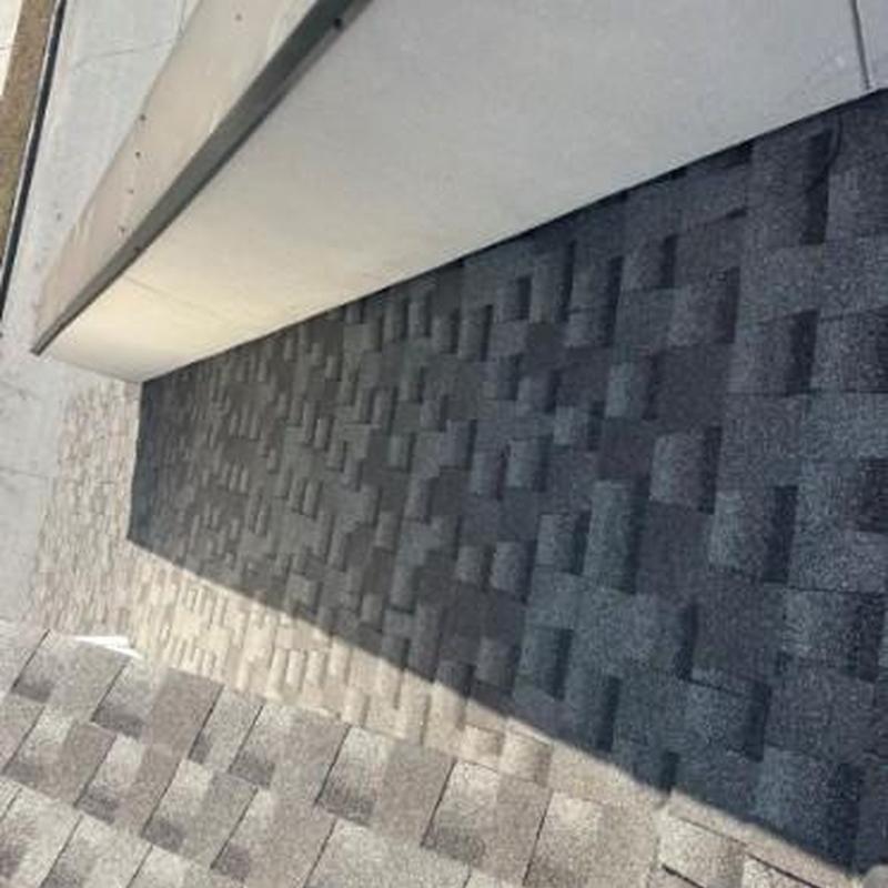 Asphalt shingle roof section with shadow on townhouse