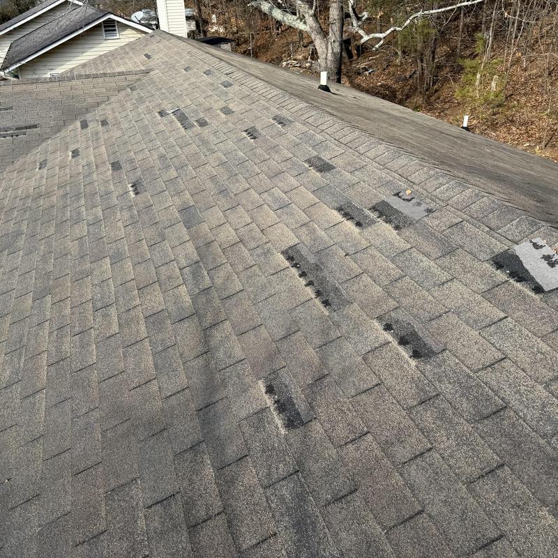Faded slate shingle roof with multiple missing shingles