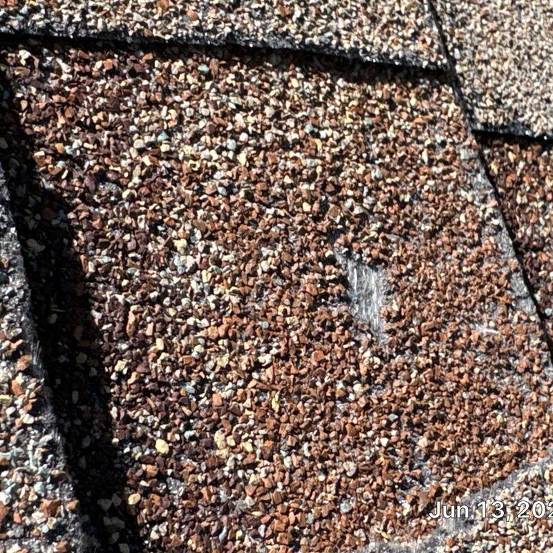 Asphalt shingle roof close-up with damage spot