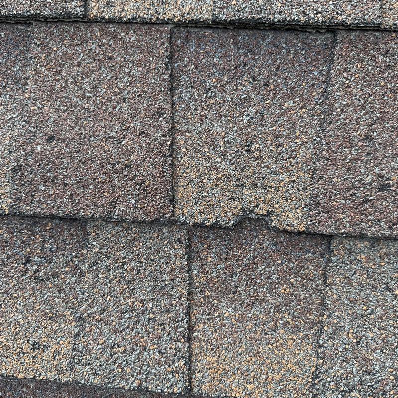 Asphalt shingle roof with damaged granules close-up