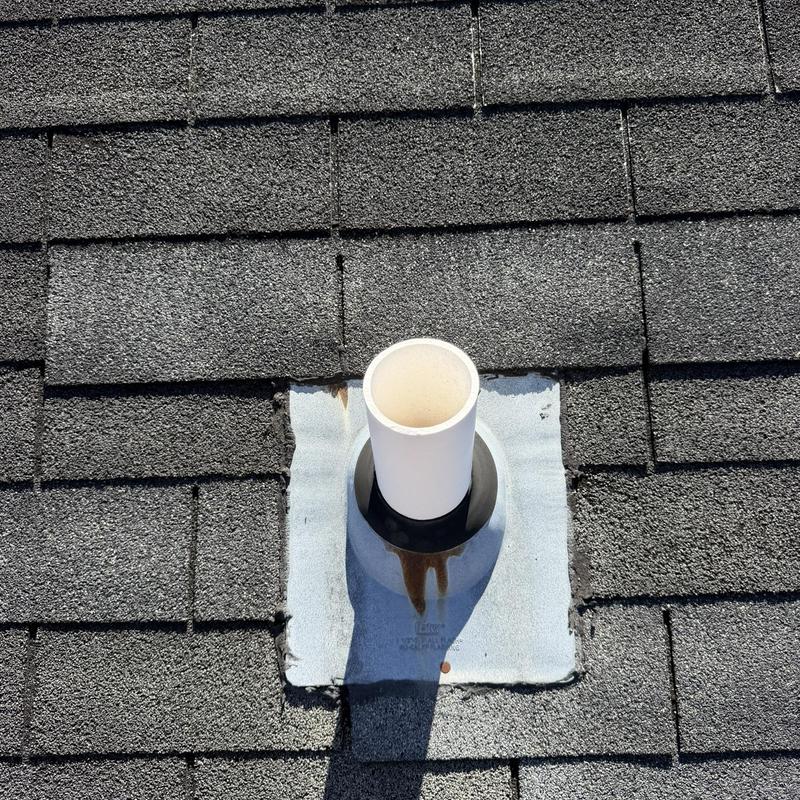 Roof plumbing vent pipe with metal flashing and shingles