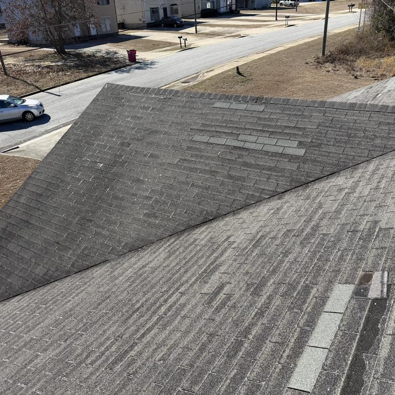 Asphalt shingle roof with patch repairs visible