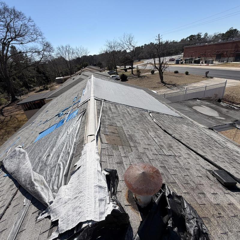Shingle roof with torn underlayment and vent pipe