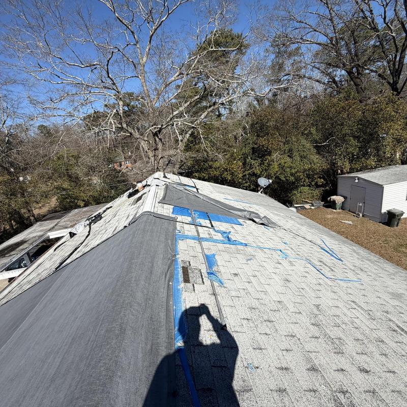 Flat roof framing rot with removed shingles and tarps