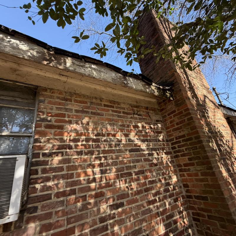 Wood fascia and soffit damage on brick house exterior