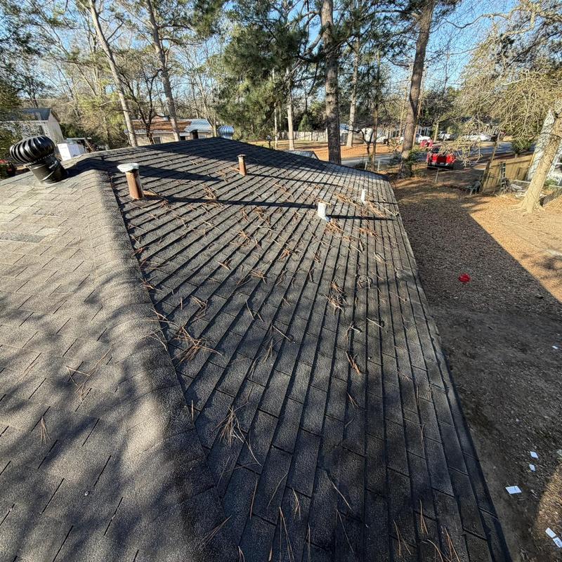 Asphalt shingle roof with vent pipes and debris