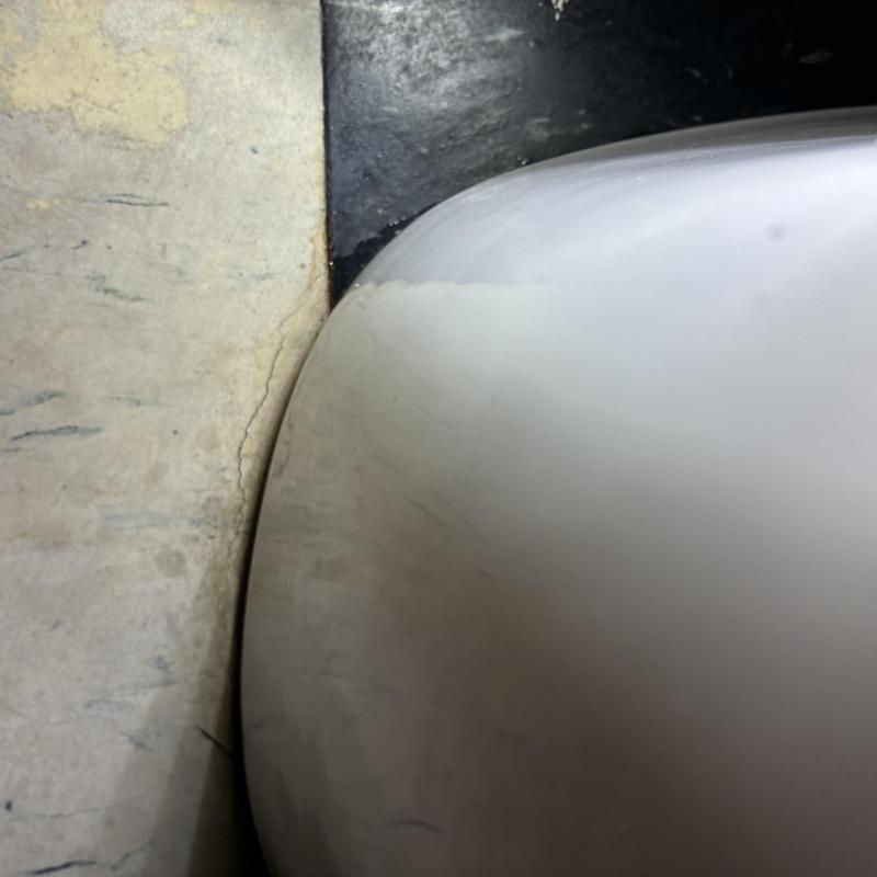 Toilet base close-up showing floor connection detail