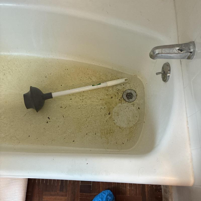 Shower drain with plunger in dirty bathtub