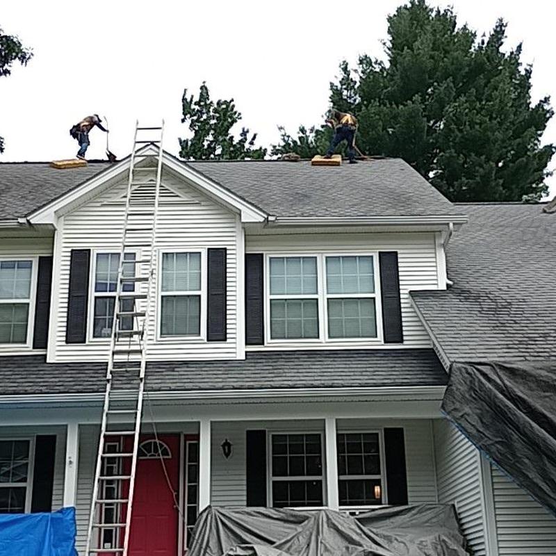 Asphalt shingle roof installation with ladder setup