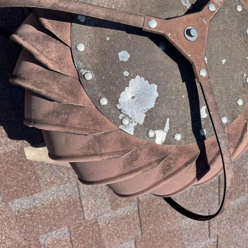 Metal roof turbine vent with hail damage on shingles