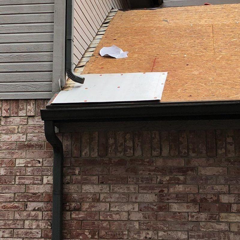 Roof deck sheathing with new metal flashing and downspout