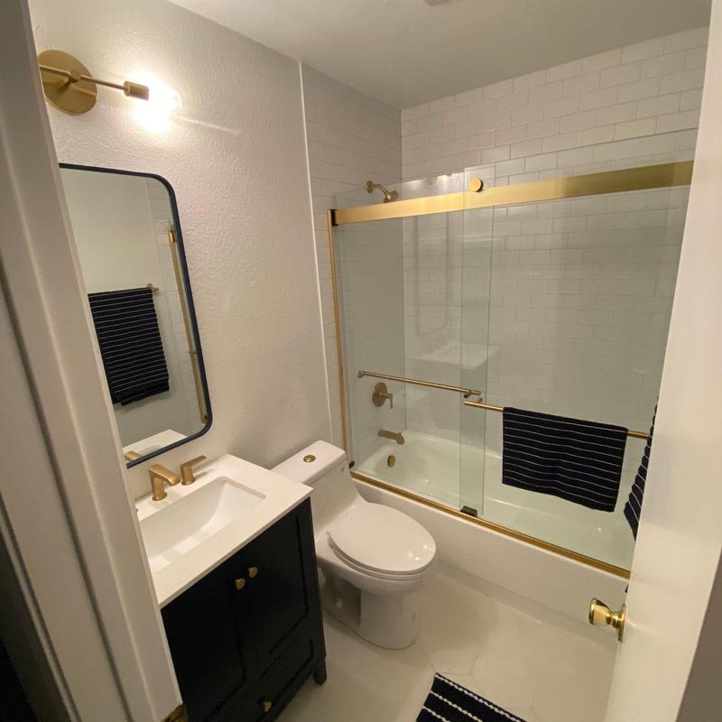 Shower with brushed brass fixtures and glass doors Shower with brushed brass fixtures and glass doors