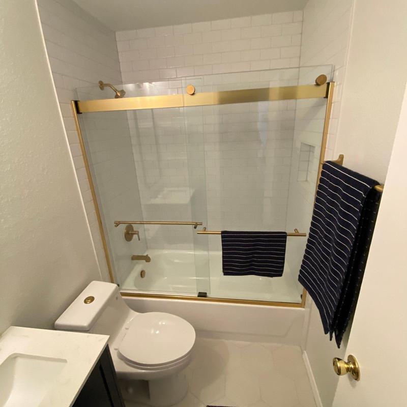 Brushed brass shower door and fixtures in bathroom Brushed brass shower door and fixtures in bathroom