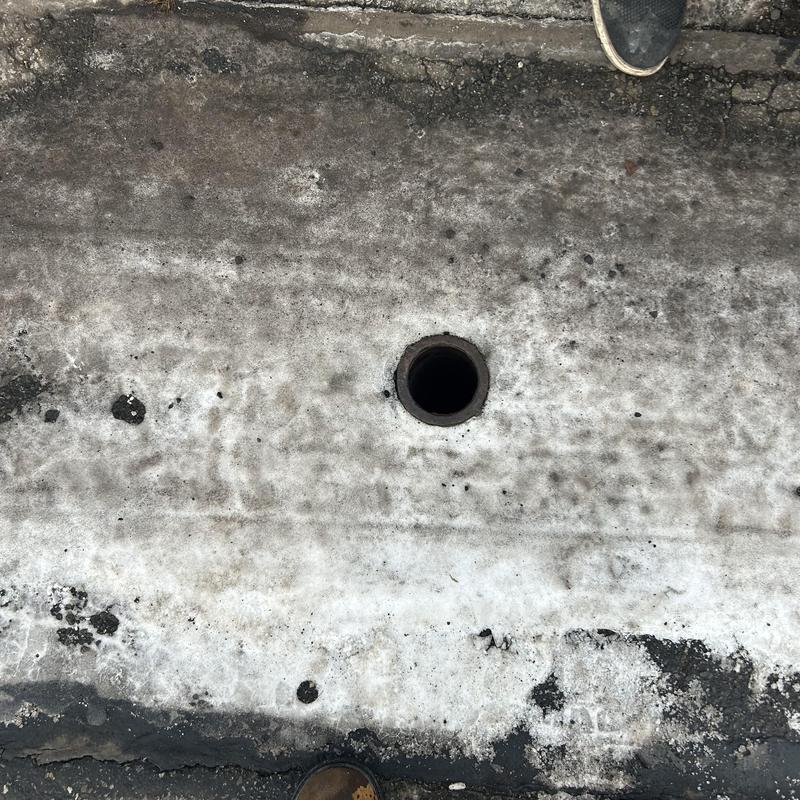 Sewer clean out pipe opening in icy pavement