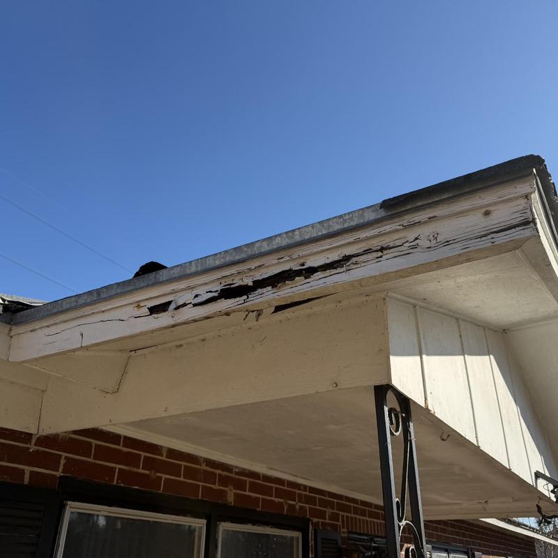 Rotted fascia board on front porch roof edge