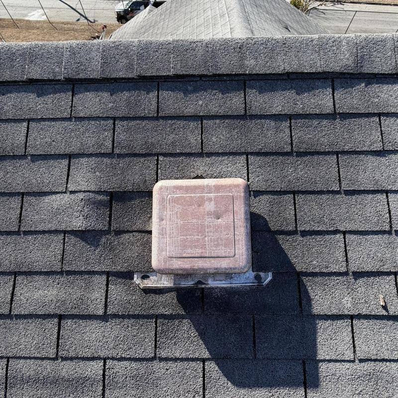 Roof shingles with vent pipe flashing on sloped roof