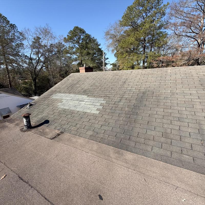 Asphalt shingle roof with flat rolled roofing section