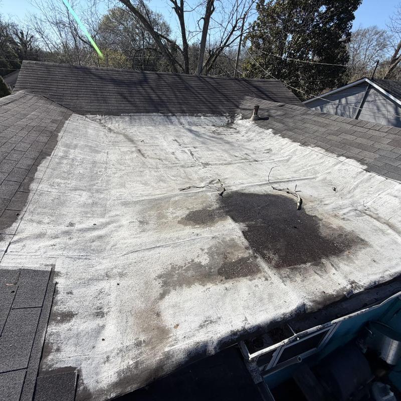 Flat roof membrane with visible damage and debris
