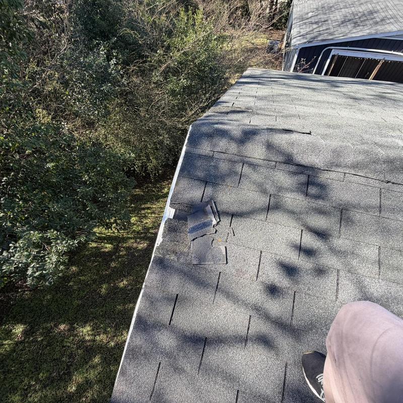 Roof shingles with visible damage on house edge