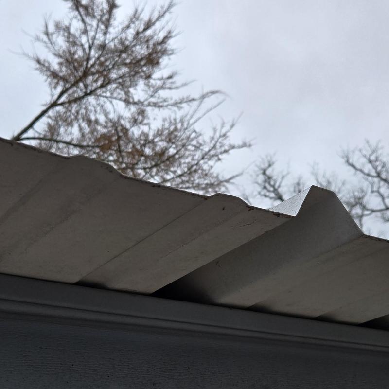 Metal roofing panel close-up with hail and wind damage inspection